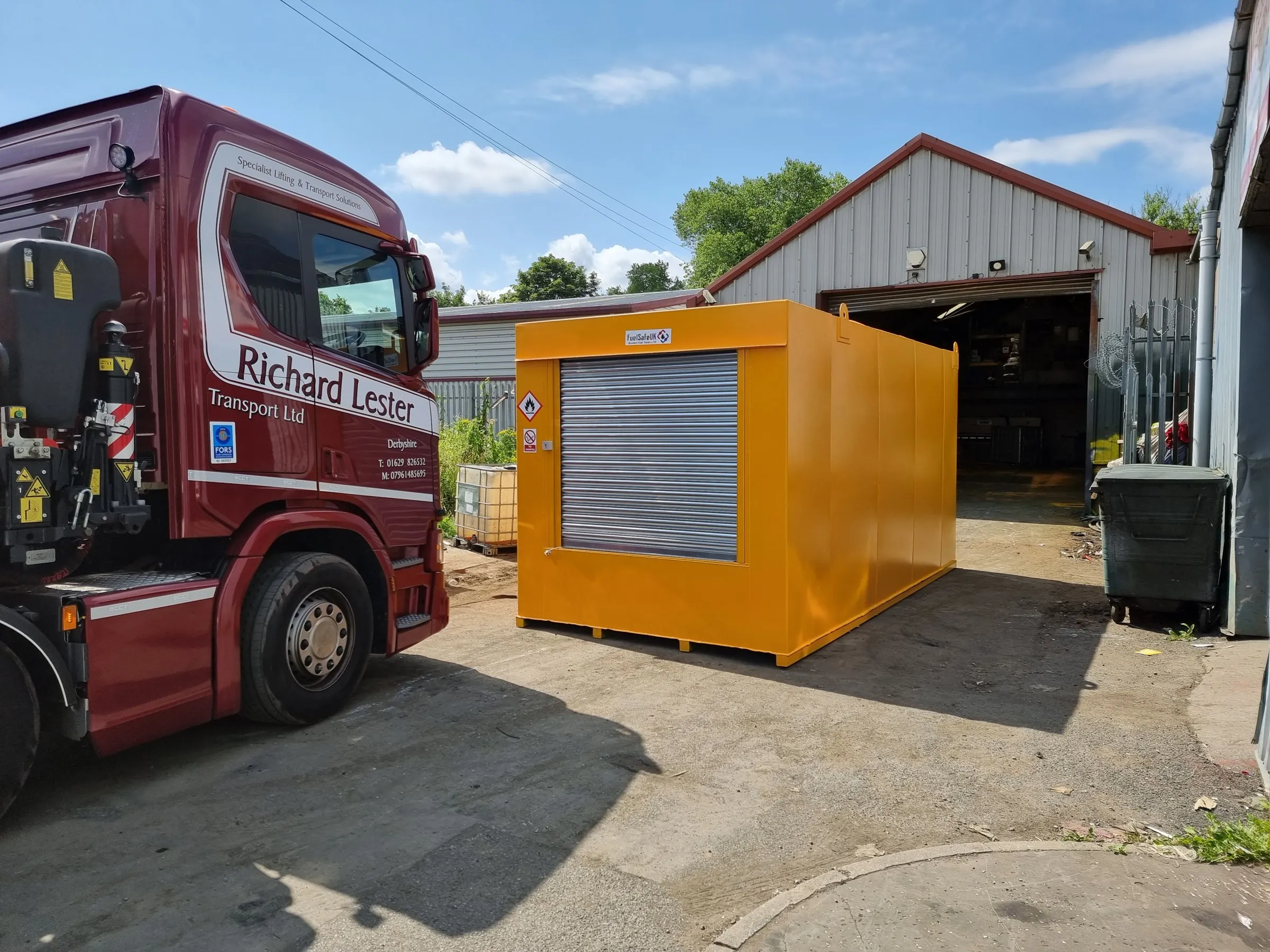 Orange bunded fuel tank with roller shutter being collected for delivery