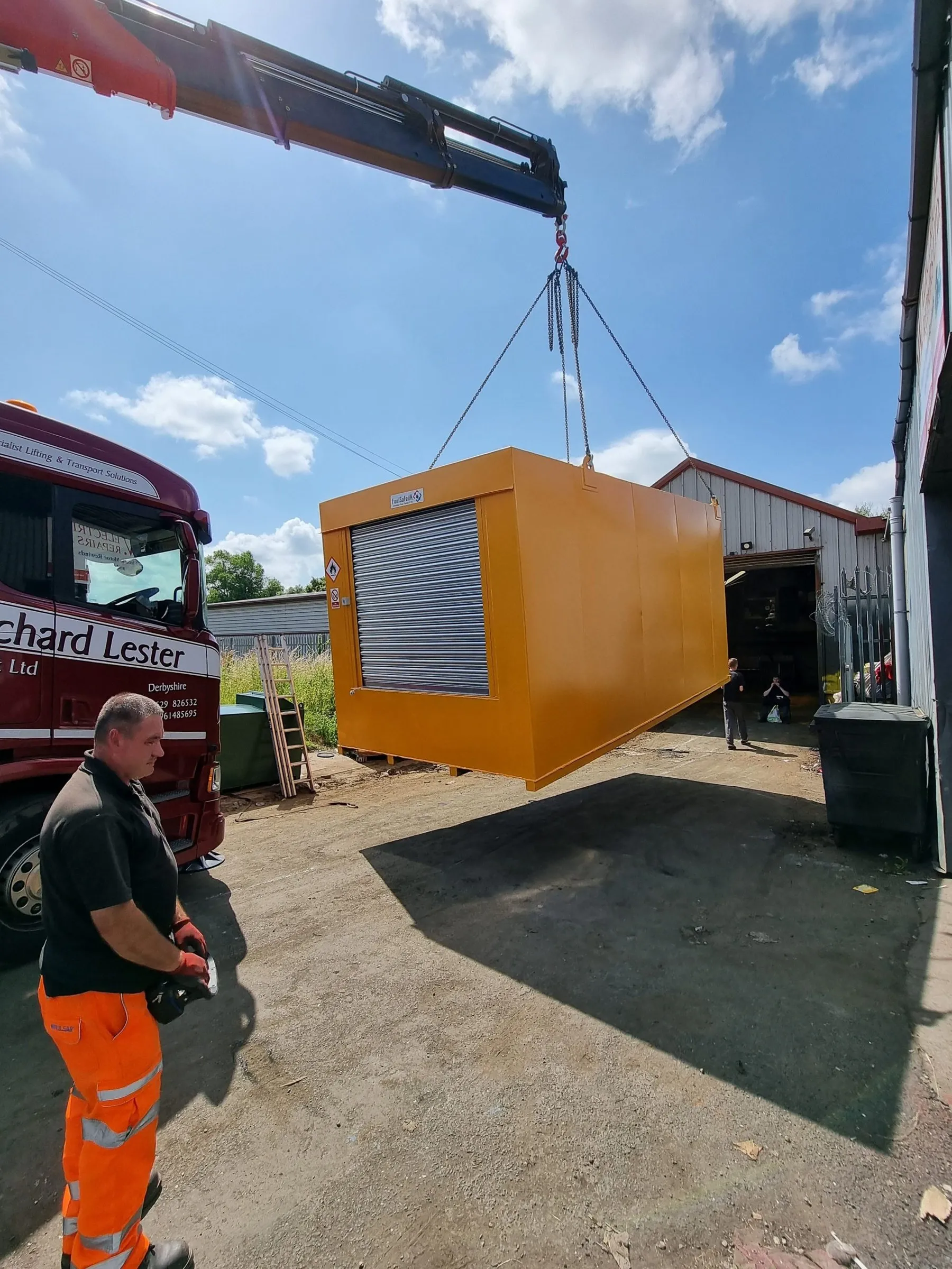 Orange 30,000 litre bunded fuel tank being craned off a lorry on delivery